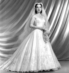 an old black and white photo of a woman in a wedding dress with a veil