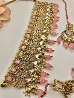 This is a beautiful Choker that comes with a set of earrings and maangtika. Can be worn on any outfit or for a bridal look as its a complete set. Comes in 2 colors - Pink and Beige Pink Indian Jewelry, Indian Jewelry Simple, Bridal Indian Jewelry, Bridal Indian, Jewelry Kundan, Beautiful Chokers, Kundan Jewelry, Polki Necklace, Bollywood Jewelry