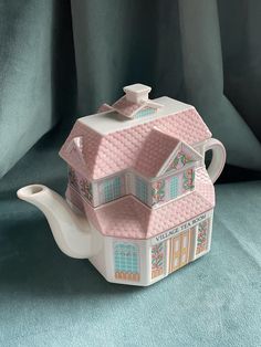 a teapot shaped like a house on a blue background