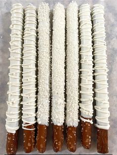 several white and brown dessert sticks lined up on top of each other with icing