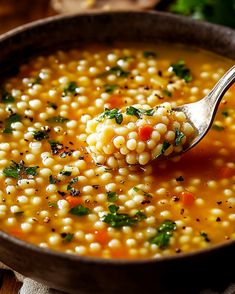 a spoon full of soup with corn and parsley