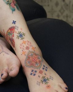 a person with colorful tattoos on their feet