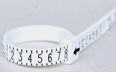 a measuring tape ring with the word measure on it's side and an arrow in the middle