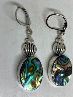 Vintage dangle earrings Main stone rainbow abalone set in white bronze Lovely handmade silver work 92.5% Sterling Silver leverback ear wires Over an inch long All jewelry is shipped in a nice gift box. Check out our over a THOUSAND great reviews Adjustable Silver Oval Earrings, Silver Abalone Shell Earrings Gift, Iridescent Abalone Shell Drop Earrings, Unique Oval Nickel-free Earrings, Iridescent Adjustable Pierced Earrings, Handmade Silver Abalone Shell Earrings, Gift Abalone Shell Earrings, Nickel-free Abalone Shell Drop Earrings, Nickel-free Abalone Shell Earrings For Gift