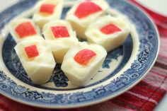 small pieces of white chocolate with red and yellow toppings on a blue and white plate