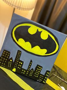 a batman themed birthday party with black and yellow decorations, bat symbol and cityscape