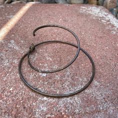 a pair of metal rings sitting on top of a rock