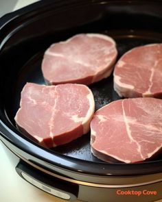 four pieces of raw meat in a slow cooker