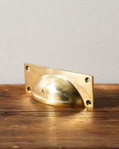 an antique brass door handle on a wooden table