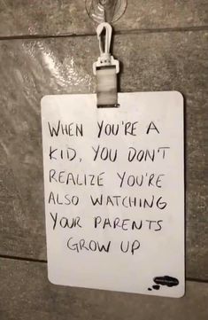 a sign attached to the side of a building that says when you're a kid, you don't really recognize how much watching your parents grow up