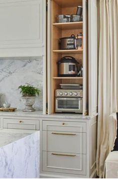 a white kitchen with marble counter tops and cabinets in the corner, along with an oven