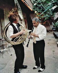 two men are playing musical instruments on the street