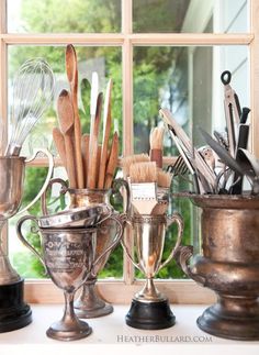 there are many different types of kitchen utensils on the counter and in front of a window