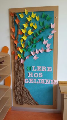 there is a bulletin board with paper butterflies on it and the words here hos gelidiz