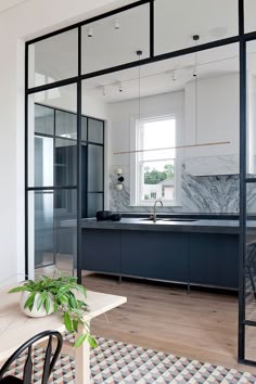 an open kitchen and dining room with glass walls