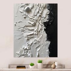 a white and black abstract painting on a wall