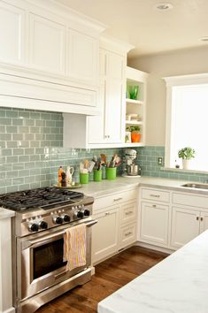 a kitchen with white cabinets and stainless steel appliances