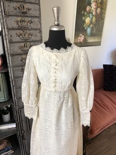 "<> 1960's 70's dress <> Color: White <> Acetate underlay, tulle layer and then lace overlay <> Sheer sleeves <> Faux button front <> Scalloped lace neckline and hem <> Nylon zipper back <> Excellent condition with light to normal wear <> Label: Emma Domb Measurements: Length: 52\" Bust: 34\" Waist 26\" Hips: open" Vintage Long Sleeve Dresses With Lace Patchwork, Vintage Dress With Long Lace Sleeves, Vintage Long Sleeve Lace Dress With Lace Sleeves, Vintage Lace Dress With Long Lace Sleeves, Long Sleeve Dresses With Lace Trim For Vintage Events, Vintage Spring Dresses With Lace Cuffs, Spring Vintage Dress With Lace Cuffs, Vintage Dresses With Lace Cuffs For Spring, Victorian Lace Dress With Long Sleeves