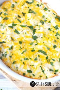 a cheesy casserole in a white dish with green garnish