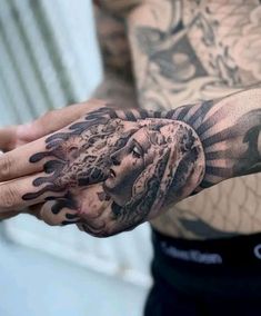 a man's arm with tattoos on it and his hand covered in black ink