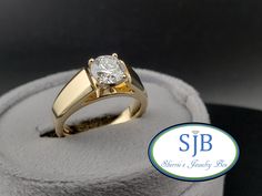 a diamond ring sitting on top of a white velvet covered display box with the logo sib