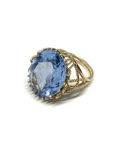 This stunning Blue topaz ring in 14k solid gold is a show stopper. This bold statement ring has the beautifully faceted oval December birthstone set in a 18 prong setting. The intricate gold details on the basket of the ring are stunning. This vintage ring with a large 20 x 16 mm blue topaz is in excellent shape. Metal: 14k goldWeight: 8 gmsGemstone: Blue TopazGemstone Size: 20 x 16 mmRing Size: 7All jewelry comes boxed ready for gift giving.LAYAWAY AVAILABLE for items over $100.  Please contact Luxury Antique Topaz Ring With Center Stone, Luxury Hallmarked Collectible Topaz Ring, Blue Topaz Ring Gold, Engagement Ring Enhancers, Gold Topaz Ring, Gold Gemstone Ring, Ringe Gold, 18k Gold Ring, Ring Blue