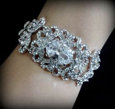 "A Victorian wedding style bridal bracelet made of clear swarovski crystals with a big oval cubic zirconia set onto detailed curl swirl frames in silver rhodium tarnish resistant finish. Bracelet crystal is 1 1/8\" (3cm) wide. Main focal crystal centerpiece is fixed at 1 1/2\" long while the rest are flexible joints. View matching pieces or similar designs at https://etsy.me/2sh8gPa View other Victorian inspired accessories https://etsy.me/2uAseFc View all bracelets at https://etsy.me/S9RHlf" Glamorous Wedding Crystal Bracelet With Bling, Glamorous Silver Bracelets For Wedding, Glamorous Bling Crystal Bracelet For Wedding, Silver Crystal Embellished Wedding Bracelet, Silver Crystal Embellished Bracelet For Wedding, Dazzling Silver Crystal Bracelet For Wedding, Wedding Diamond Bracelets With Jewels, Elegant Wedding Crystal Bracelet With Bling, Dazzling Sparkling Crystal Bracelet For Wedding