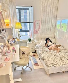 a woman laying on top of a bed in a bedroom next to a desk and chair