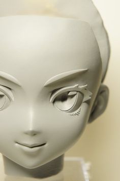 a white mannequin head with large eyes and an arrow on it's forehead