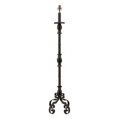 a black iron coat rack with two candles on the top and one candle in the middle