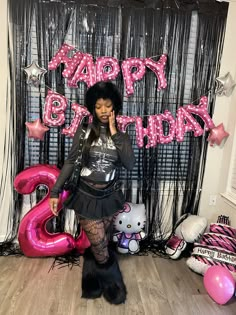 a woman standing in front of a happy birthday sign