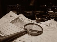 a magnifying glass sitting on top of papers next to a pipe and box