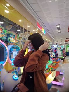 a woman standing in front of a store window taking a photo with her cell phone