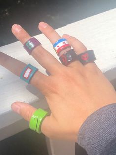 a person's hand with four rings on it and one ring has cars printed on it