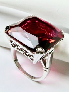 Simulated Red Ruby RingE-Ring Design#D1 This is a beautiful vintage reproduction ring. The sterling silver filigree holds an ~20 carat simulated red ruby gemstone. The man-made gemstone has perfect ruby red color and amazing clarity. The flawless high-quality square-cut gemstone is 18mm square. The stone and setting rise about 1/2" off the finger. The inside of the band is marked 925 for sterling silver. Notice the beautiful crisscross basket pattern in the silver filigree setting. This geometri Ruby Red Color, Basket Pattern, Sterling Silver Filigree, Ruby Gemstone, Square Cut, Red Ruby, Silver Filigree, Ruby Ring, Ruby Red