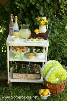 a lemonade bar is set up in the grass with lemons and other drinks