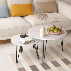 a white couch sitting next to a table with fruit on it