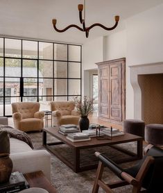 a living room with couches, chairs and a table in front of a fireplace