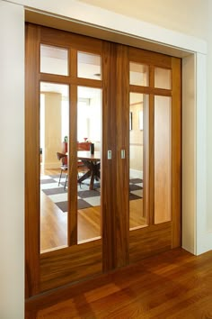 an empty room with wood floors and glass doors