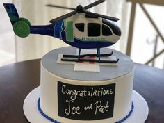 a birthday cake with a helicopter on top and congratulations to joe and pat written on it