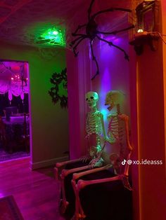 two skeletons are sitting in the corner of a room with purple and green lights on