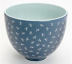 a blue bowl with small white flowers on it's rim, sitting in front of a white background