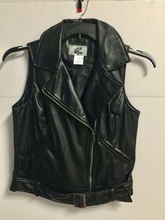 REV UP YOUR STYLE IN THIS WOMEN'S "COOL" FAUX LEATHER MOTO VEST BY "BROOME & ALLEN"...SIZE SMALL (PLEASE CHECK MEASUREMENT FOR CORRECT SIZE)...NEW W/O TAGS...BLACK FAUX LEATHER POLYURETHANE...BLACK POLYESTER SATIN LINING...BUST MEASURES 19" FLAT ACROSS PIT TO PIT...18" WAIST...21" BACK LENGTH... ***LIVE ON THE WILD SIDE, AND GO FOR IT!!... <> KEEP CHECKING MY AUCTION FOR MORE "MOST WANTED" APPAREL FROM MY ZANY WOMEN'S VEST COLLECTION...THANKS FOR LOOKING...HAPPY BIDDING!...YOUR BUSINESS IS GREAT Edgy Vest For Biker Events In Fall, Black Fitted Biker Vest, Edgy Black Vest For Fall, Black Fitted Moto Vest, Punk Style Vest Outerwear For Fall, Sleeveless Black Biker Jacket For Fall, Black Sleeveless Biker Outerwear, Fitted Sleeveless Biker Jacket For Biker Events, Fitted Sleeveless Biker Jacket For Events