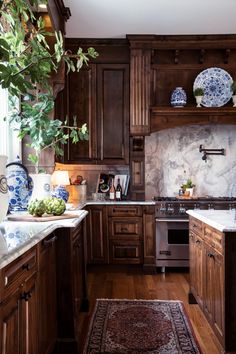 a kitchen with wooden cabinets and marble counter tops, along with a rug on the floor