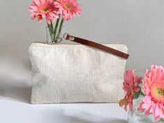 Our natural linen wristlets are the perfect combo of casual simplicity and modern minimalism. Sized just right to hold all your need when you're out and about day or night. Details: -Approximately 9.5in L x 6in H -Natural textured linen exterior -Secure zippered closure -Detachable wrist strap in real leather that is sourced, dyed and cut in the US. Leather is finished on top and left natural on the underside. -Durable unbleached twill lining -Hand or Machine washable (without strap), line dry, Minimalist Clutch, Transparent Clutch, Simple Purse, Summer Clutch, Casual Clutch, Clear Tote Bags, Wedding Clutch, Pearl Bag, Oatmeal Color