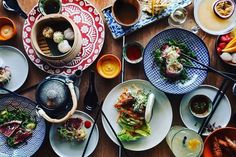 an overhead view of many plates and bowls with food on them