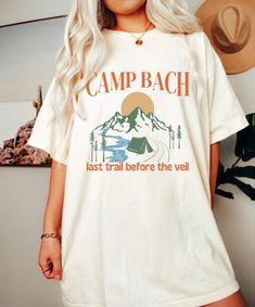 Camp Bachelorette Shirt, Comfort Colors, Camp Bach Shirt, Camping Shirt, Mountain Bachelorette, Camp Themed Bachelorette, Wild in The Woods *IMPORTANT PLEASE READ BEFORE PURCHASING* My store uses DTG (Direct to Garment) printing. This means the design is printed into the garment. This means it is designed to last longer than other printing processes. Due to this printing process the design colors may not be as vibrant as shown in the photos. There may at times be a slight difference between real Summer Camping Top With Letter Print, Summer Camping Tops With Letter Print, White Summer Tops For Camping, Summer Camping Shirt With Letter Print, Casual Summer Camp Shirt For Hiking, Summer Camping Shirt With Graphic Print, Summer Graphic Print Camp Shirt, Summer Camping Shirt With Crew Neck, Outdoor Short Sleeve Camp Shirt With Letter Print