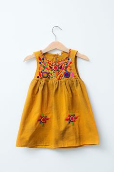 Our colorful Jardinita dresses are made of cotton are hand-embroidered making each one unique! Dresses are sleeveless and come with a button and loop on the back of neckline to secure. - available in sizes 0-4, 6 & 8 see size chart for measurements - as these are all one of a kind embroidery, color may differ from Yellow Cotton Bohemian Sundress, Bohemian Cotton Sleeveless Sundress, Yellow Cotton Sleeveless Summer Dress, Sleeveless Cotton Embroidered Dress, Bohemian Sleeveless Cotton Sundress, Sleeveless Dress With Multicolor Embroidery For Spring, Traditional Sleeveless Cotton Embroidered Dress, Traditional Sleeveless Embroidered Cotton Dress, Sleeveless Cotton Embroidered Dress For Beach