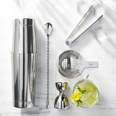 there is a cocktail shaker, lemonade and other items on the table