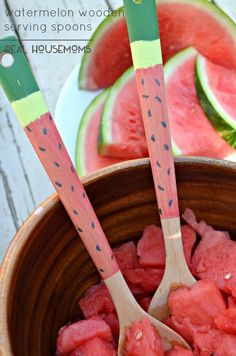 watermelon wood serving spoons in a bowl filled with watermelon slices